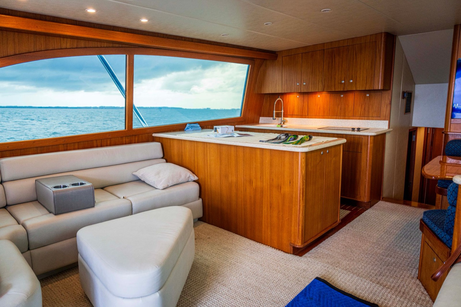 Climate-controlled teak yacht salon with storm-gray sea beyond the window